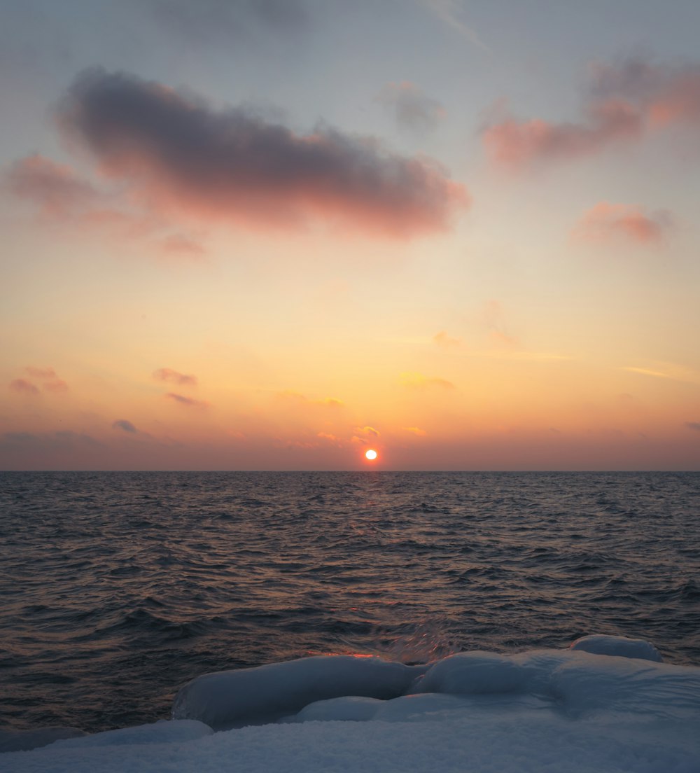 ocean under orange sky during sunset