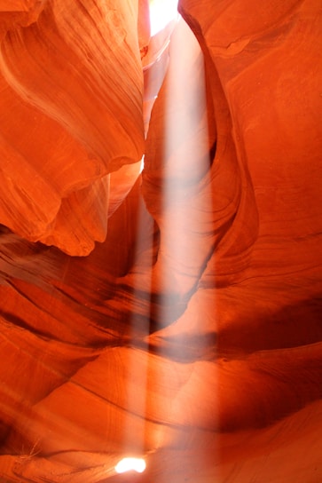 Sunlight streaming through the narrow, winding walls of Antelope Canyon, highlighting the rich red and orange sandstone textures.