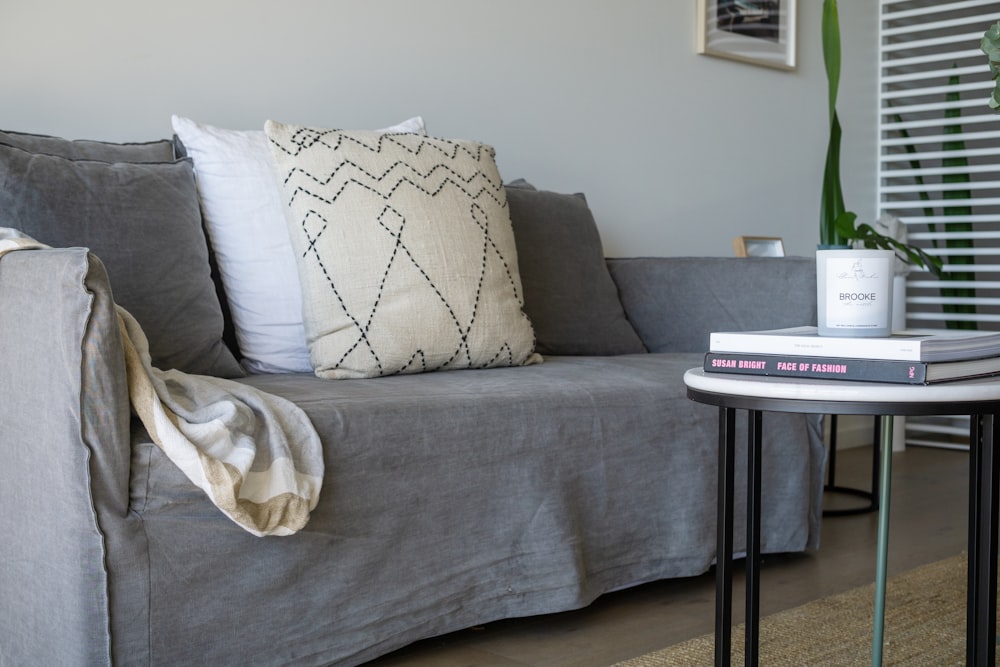 white and gray floral throw pillow on gray sofa