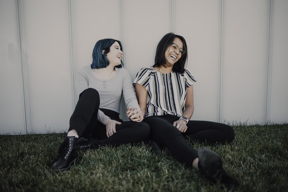 2 women sitting on green grass