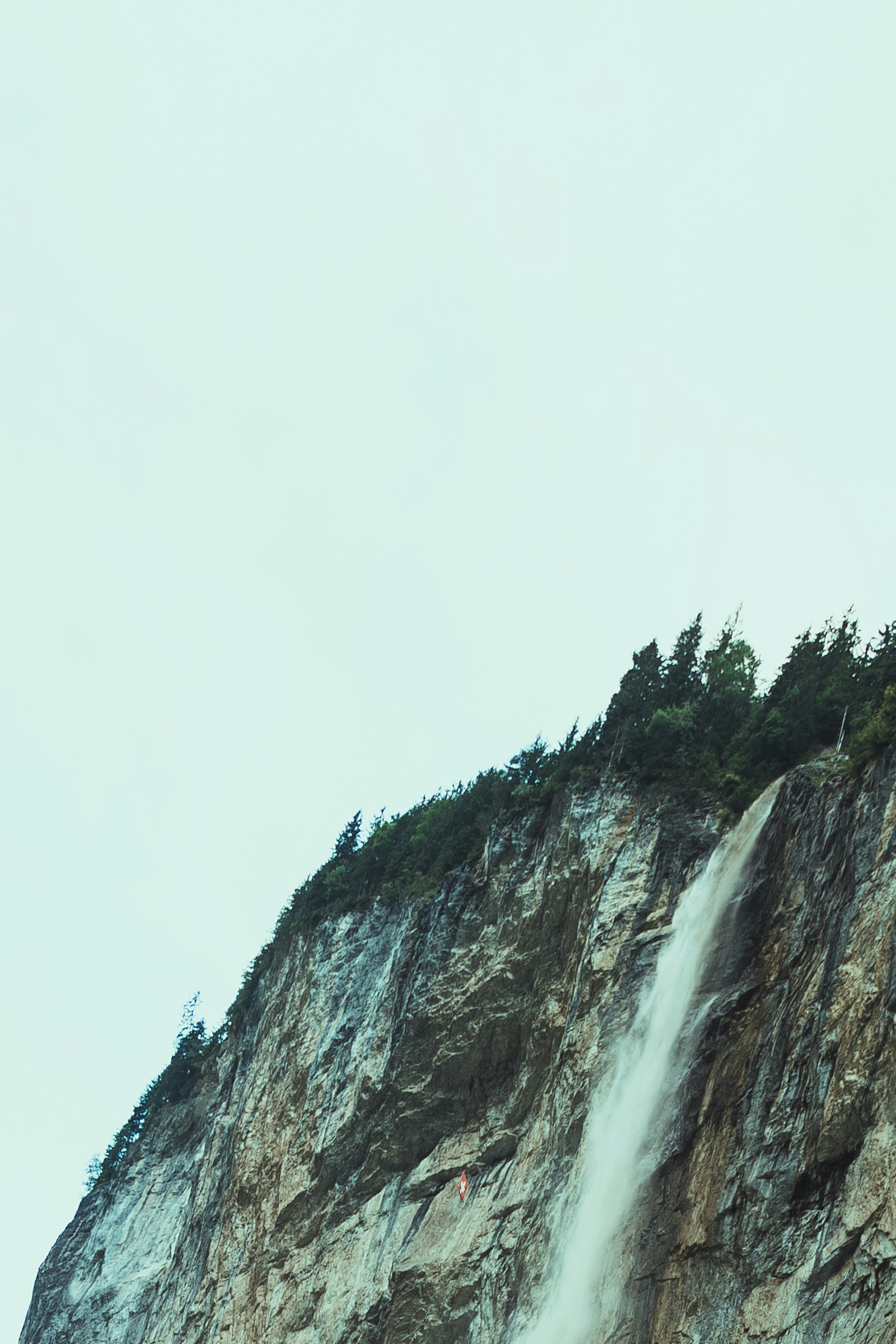 waterfalls under white sky during daytime