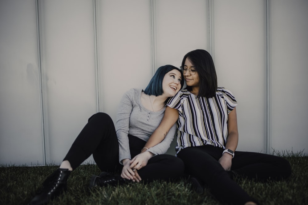 2 women sitting on green grass