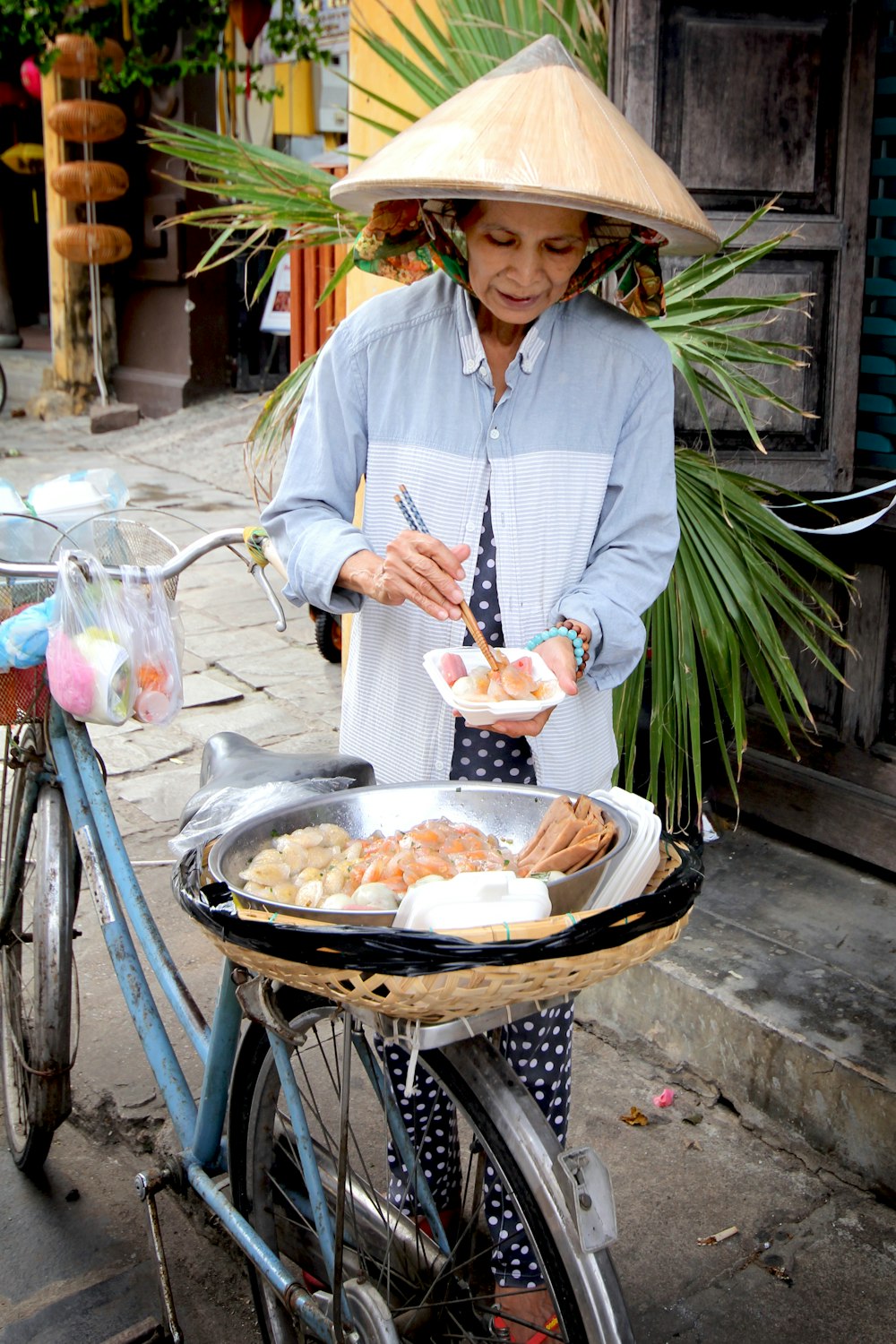 woman in white long sleeve shirt holding a tray of food