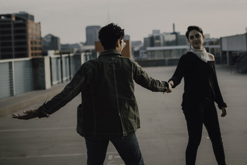 woman in black jacket and pants holding hands with woman in black jacket