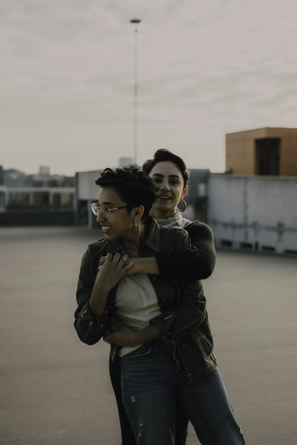 woman in black jacket hugging woman in gray jacket