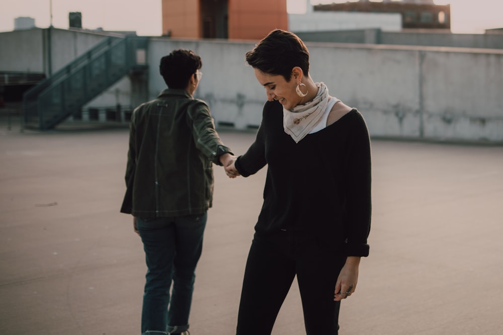 woman in black jacket holding woman in white shirt