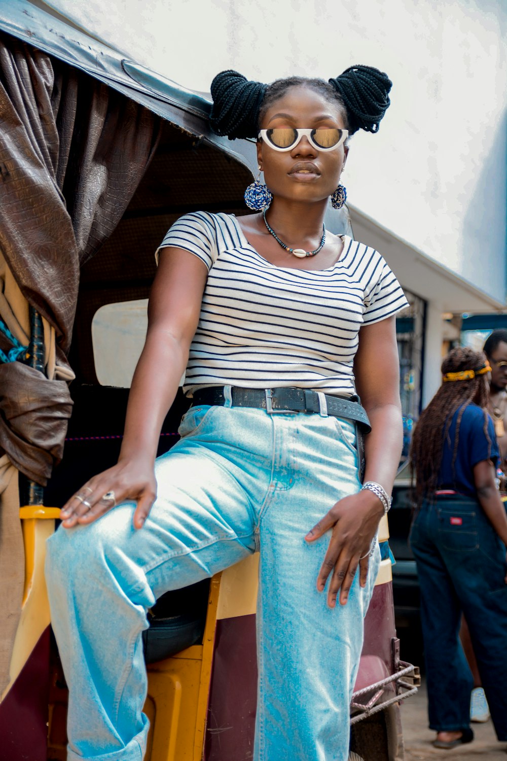 woman in blue denim jeans sitting on yellow plastic chair