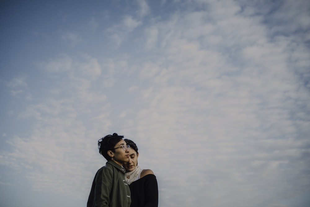 woman in black shirt standing under white clouds during daytime