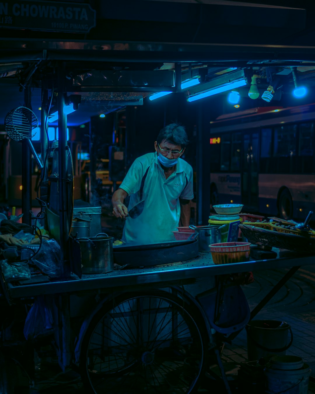 man in white button up shirt standing near food cart