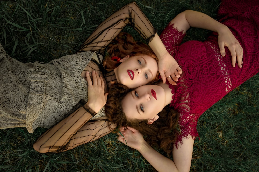 woman in red dress lying on green grass