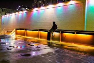 A lone figure standing beneath a neon-lit bridge with glitching lights.