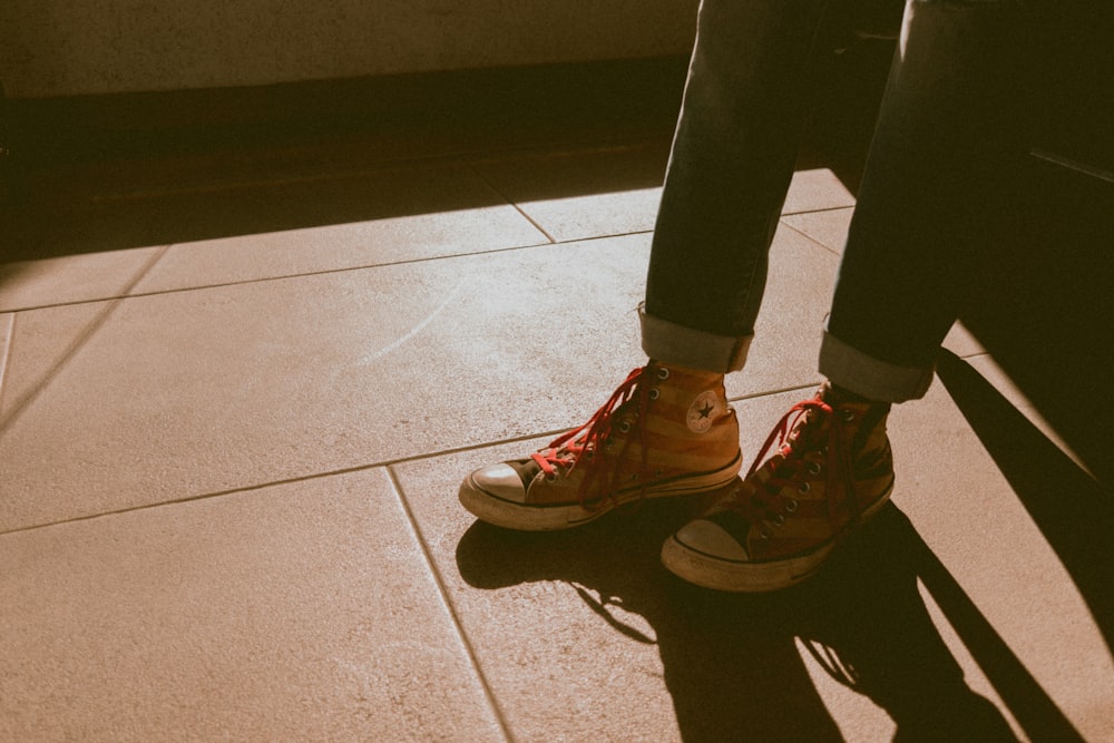 person in black pants and red nike sneakers