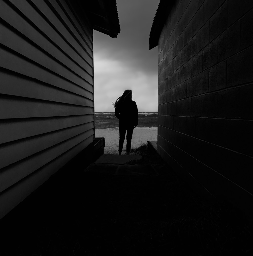 woman in black dress standing on tunnel