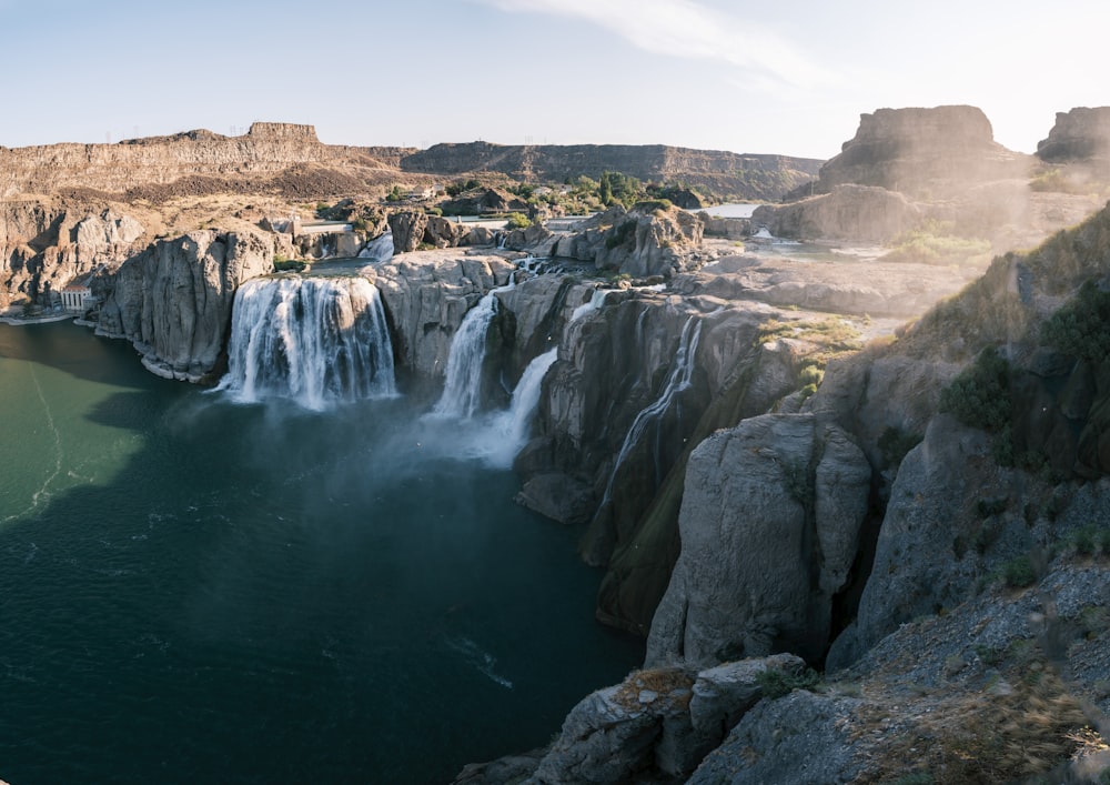 waterfalls near brown rock formation during daytime