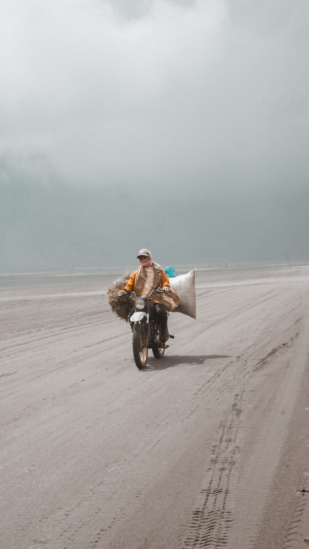 man in brown jacket riding motorcycle on road during daytime