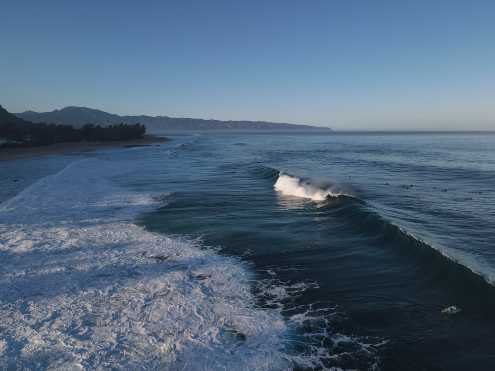 ocean waves crashing on shore during daytime