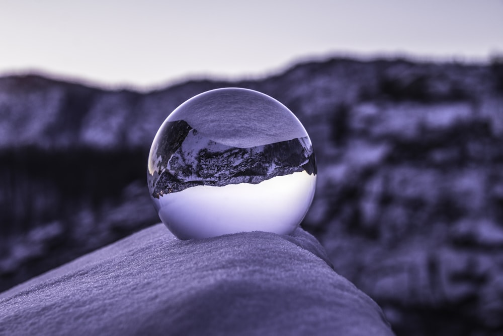 clear glass ball on gray textile