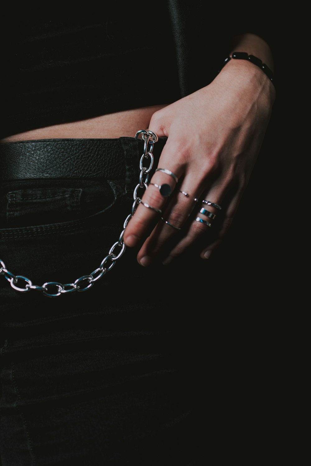 person wearing silver ring and black leather bag