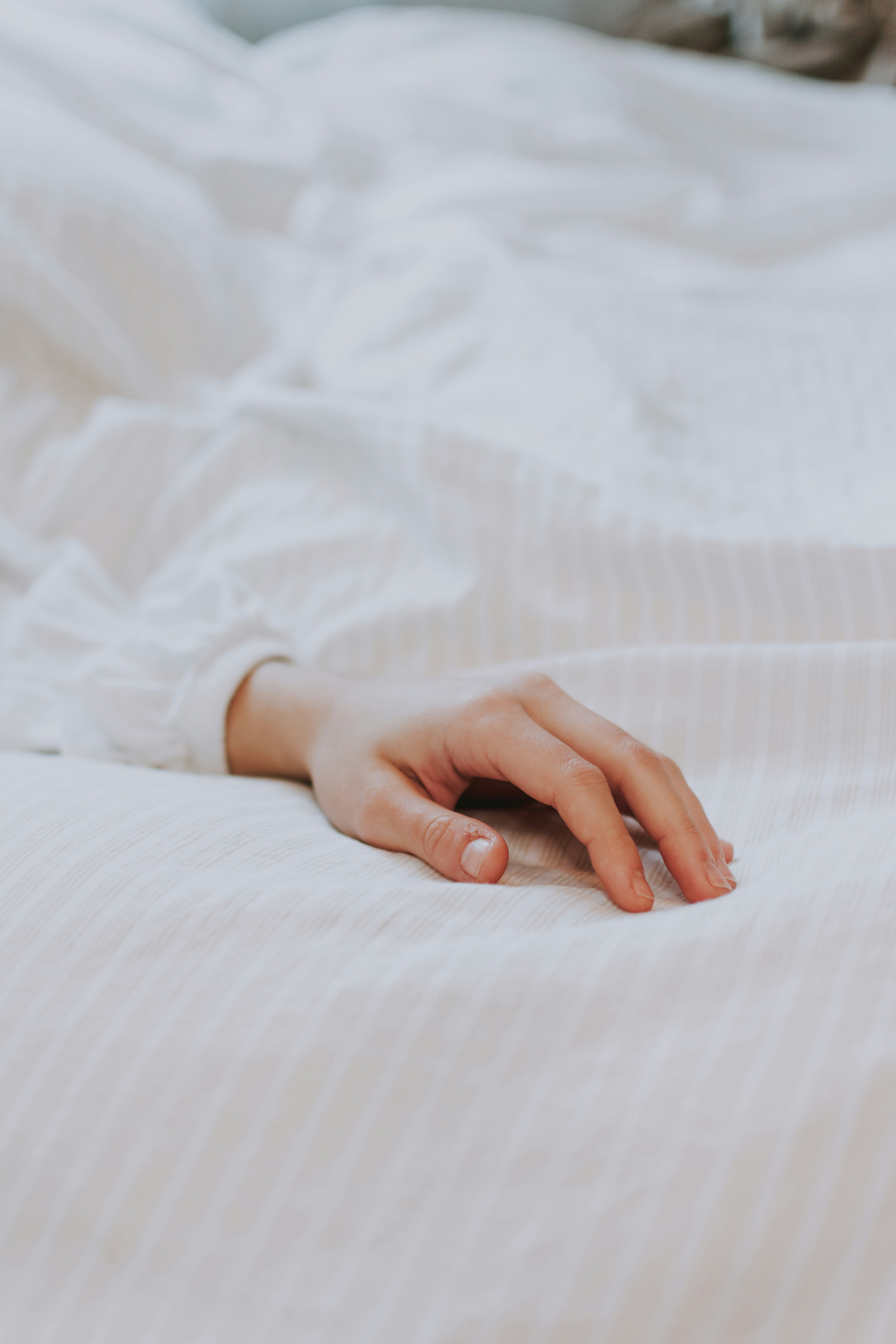 persons hand on white textile