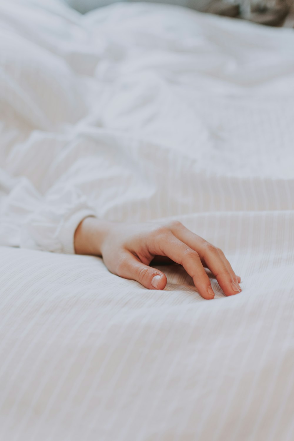 persons hand on white textile