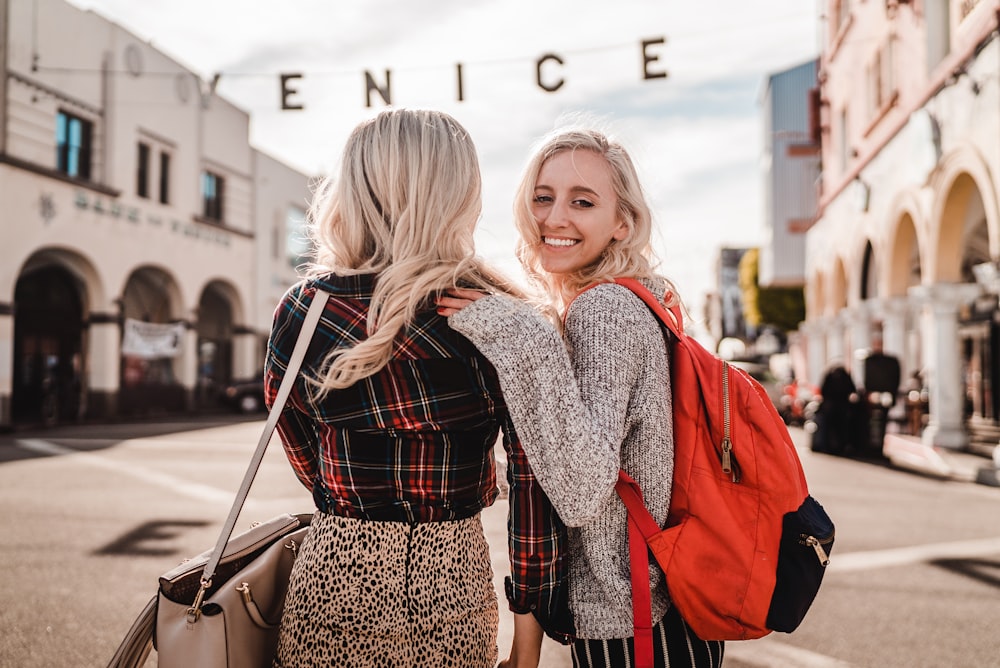 woman in black and white long sleeve shirt carrying girl in red jacket