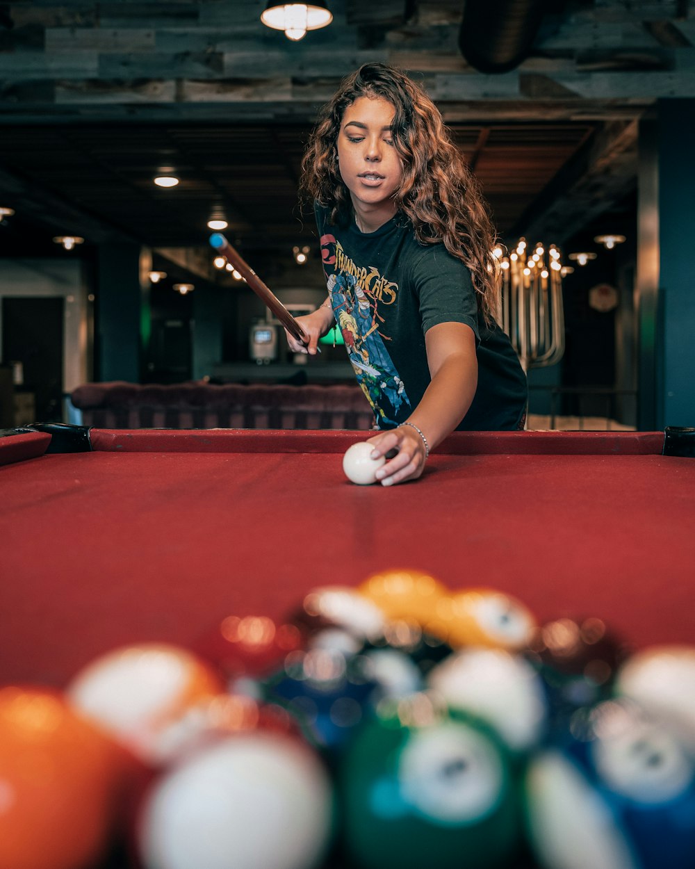 girl in blue and white crew neck t-shirt playing billiard