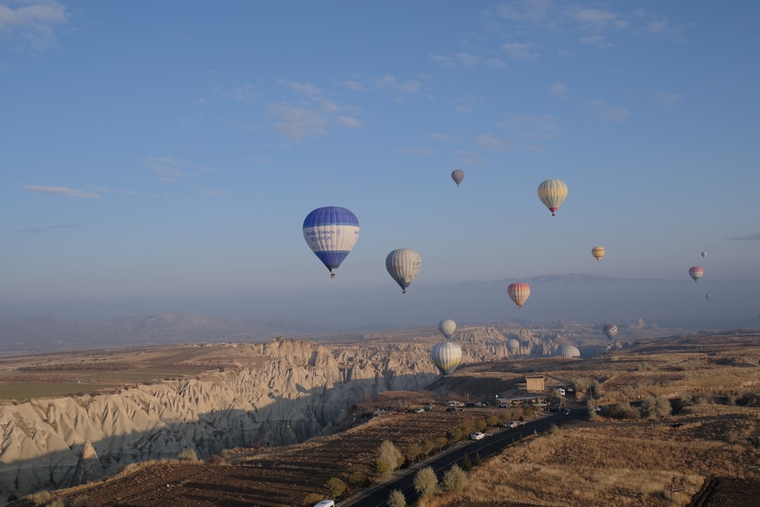 hot air balloons flying over the brown field during daytime