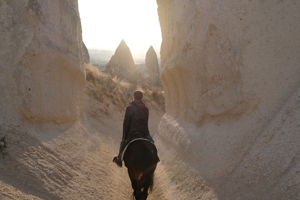 man in black jacket walking on brown dirt road during daytime