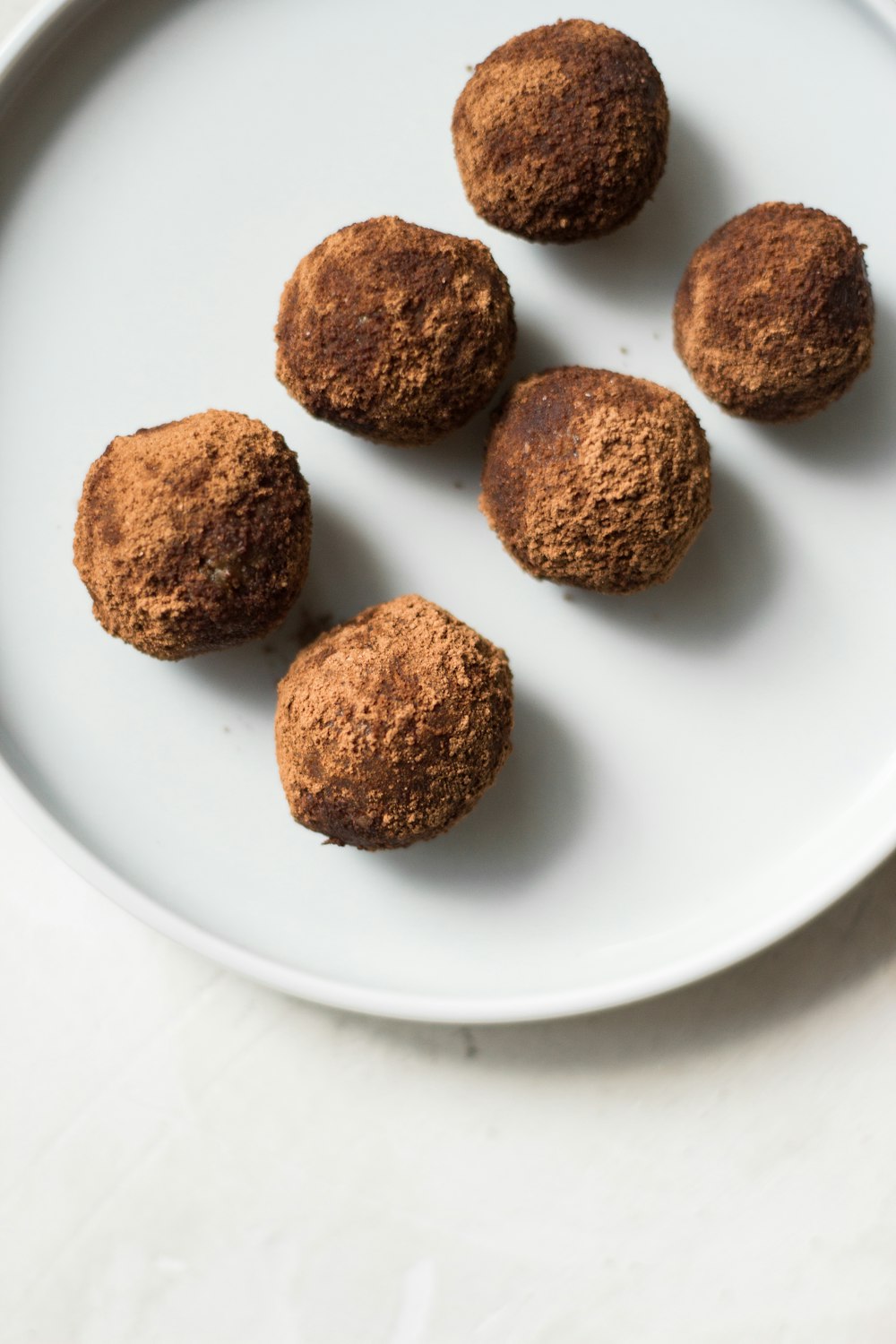 three brown cookies on white ceramic plate