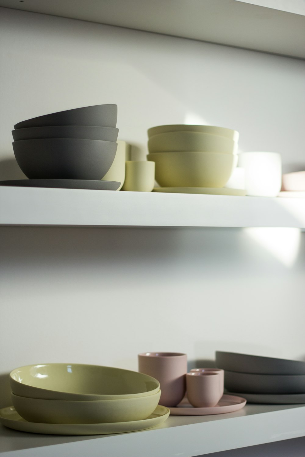 white ceramic bowls on white wooden shelf