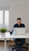 man in blue polo shirt using silver macbook