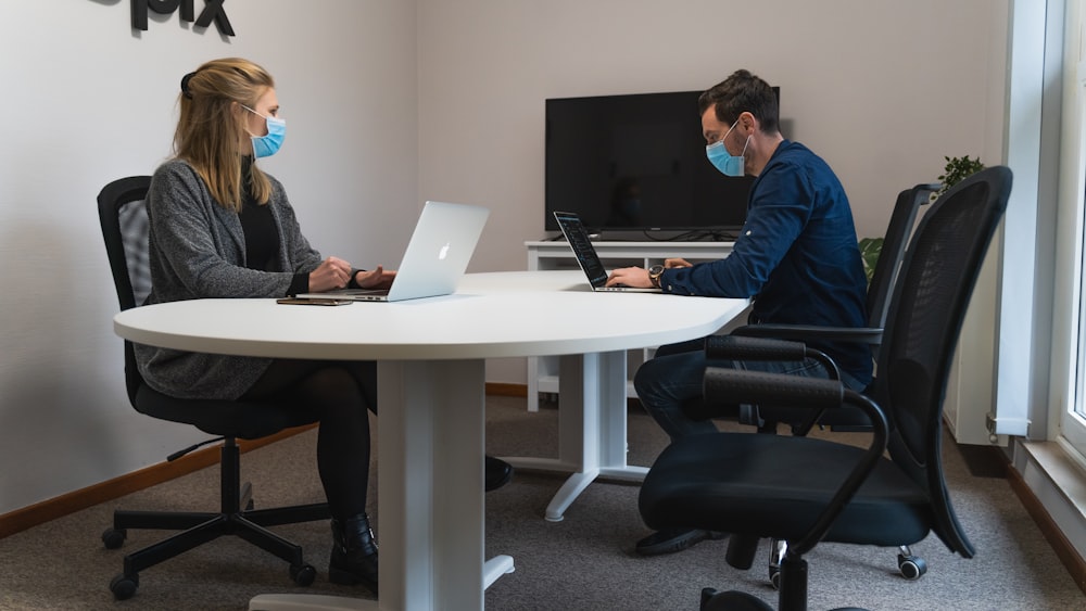 man in blue dress shirt sitting on black office rolling chair