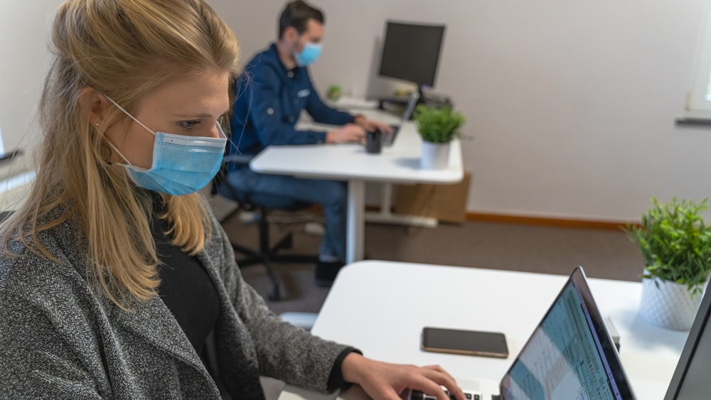 woman in black sweater holding white tablet computer