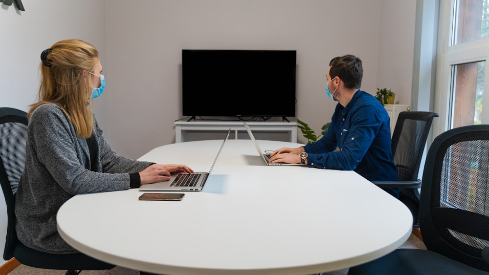 man in blue dress shirt using macbook air