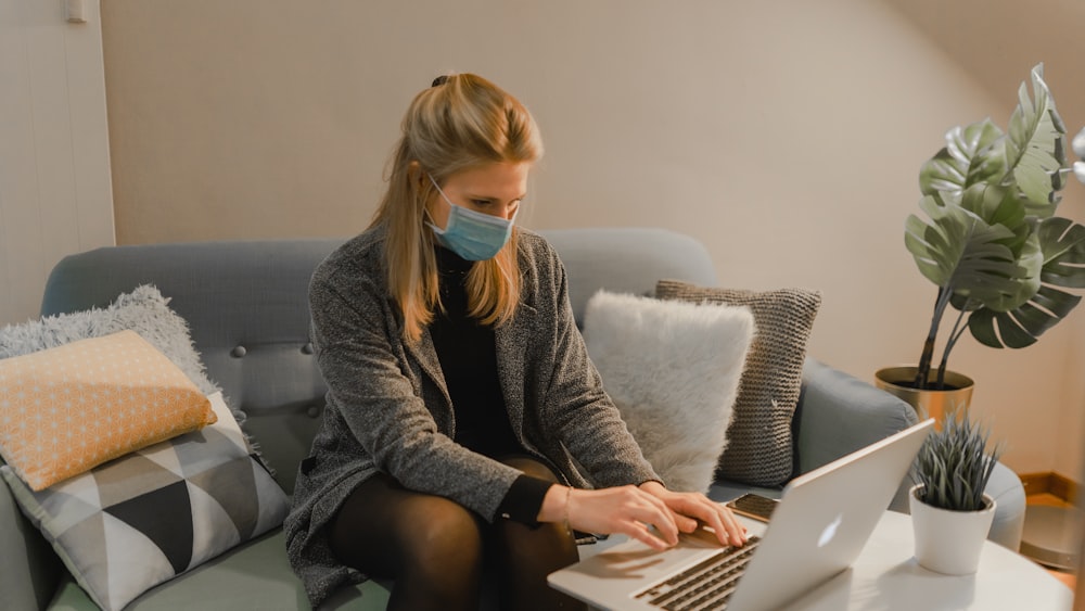 woman in gray sweater using laptop computer