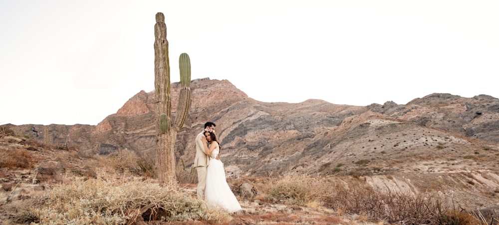 woman in white wedding gown standing beside brown tree during daytime