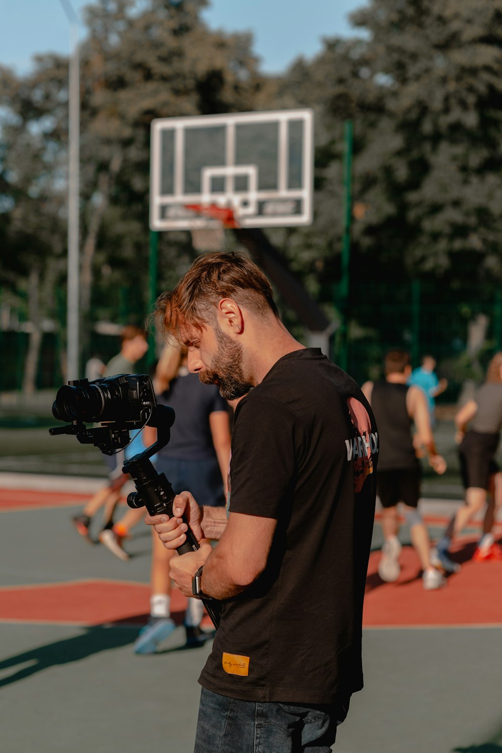 man in black crew neck t-shirt holding black dslr camera