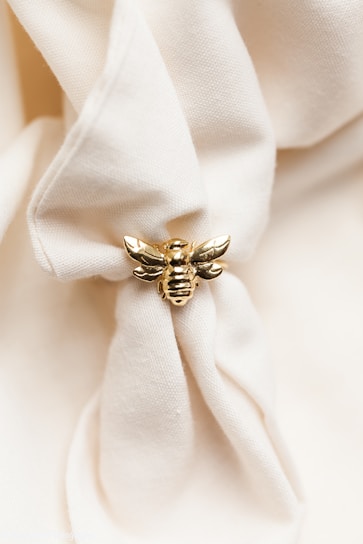 Close-up of a luxury bee logo embroidered on a stylish jacket sleeve.