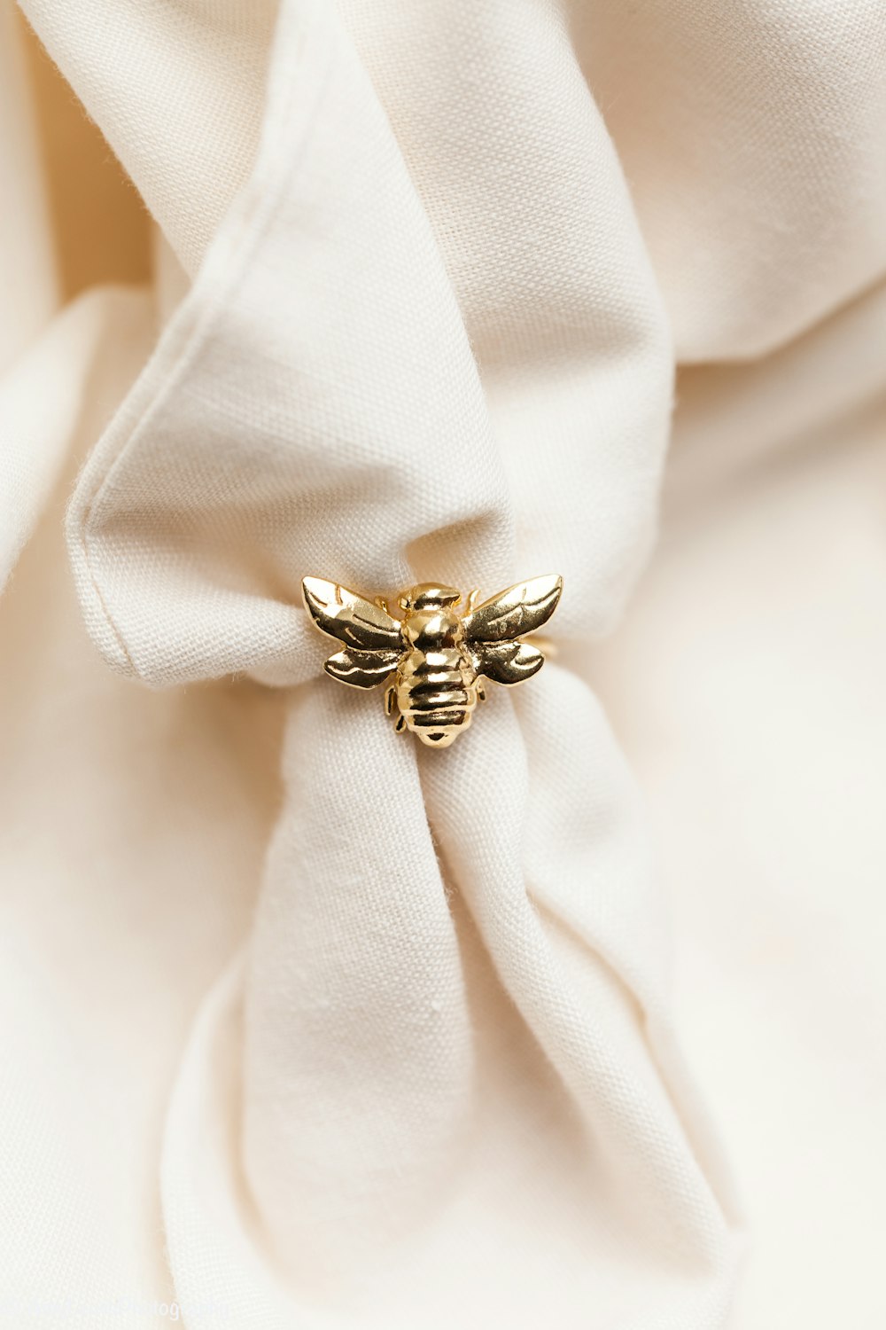 gold ring on white textile