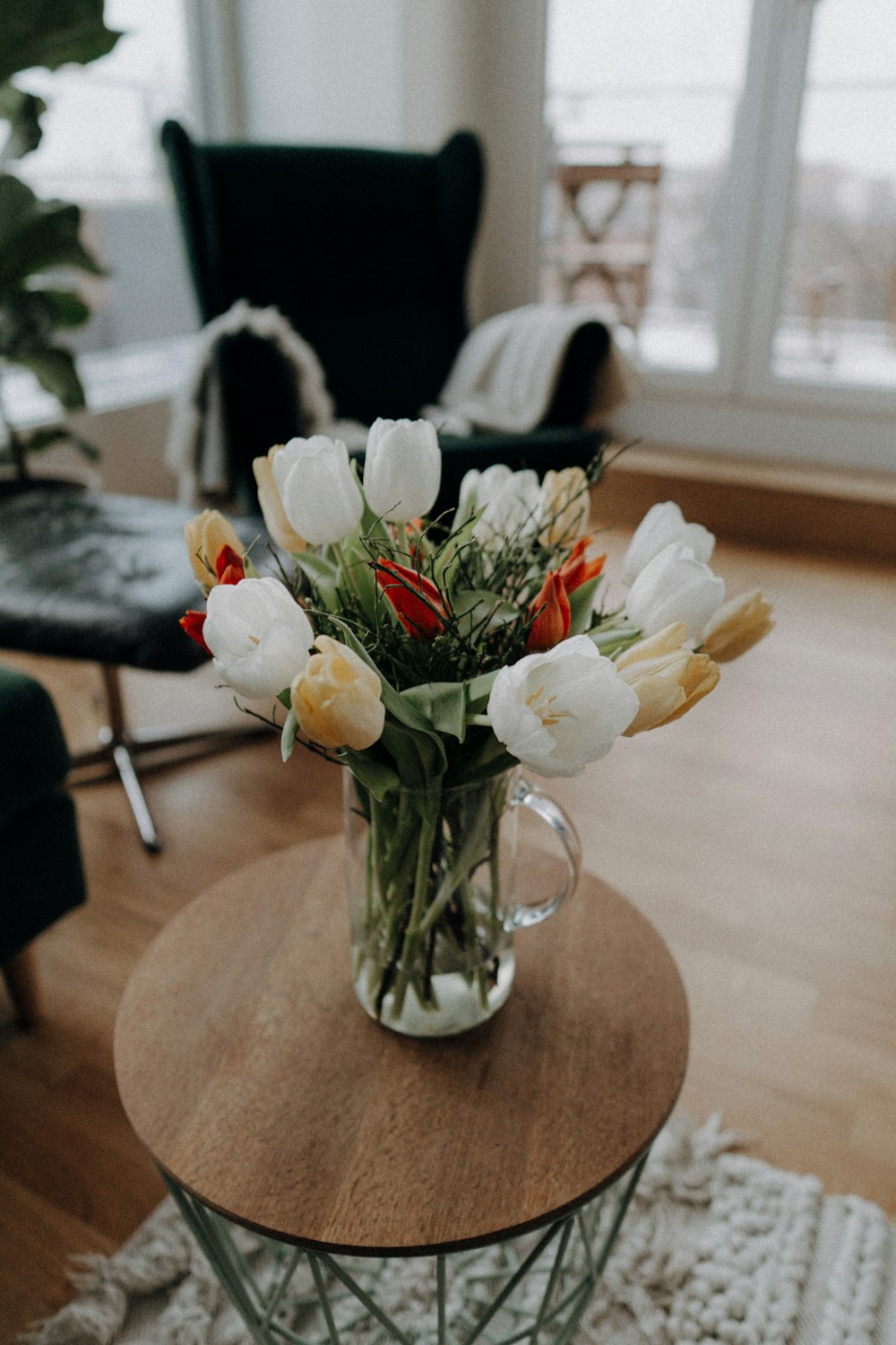 white flowers in clear glass vase on brown wooden table