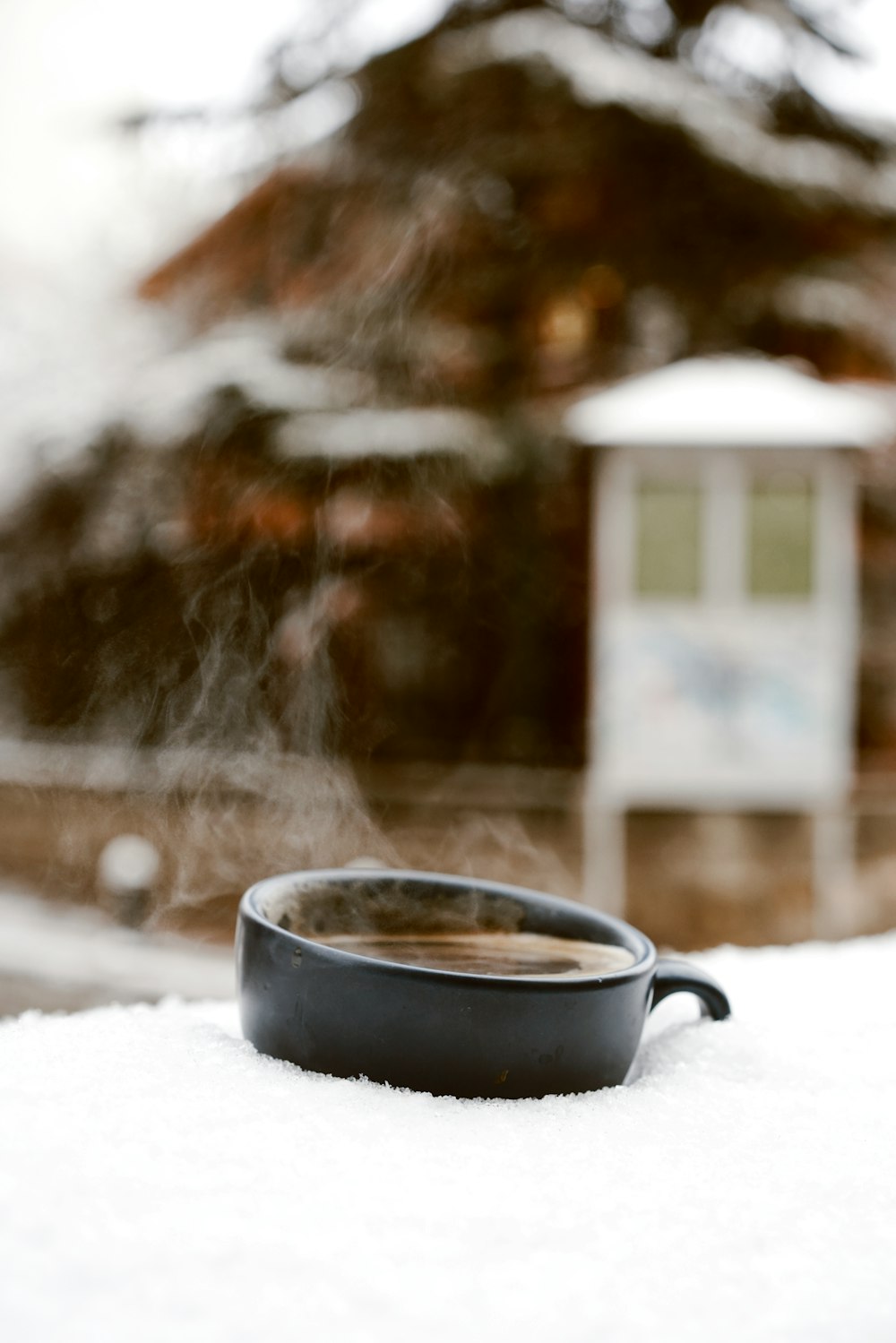 schwarzer Keramikbecher auf schneebedecktem Boden