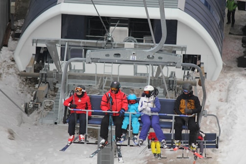 Group of friends laughing and preparing their gear before heading up the lift.