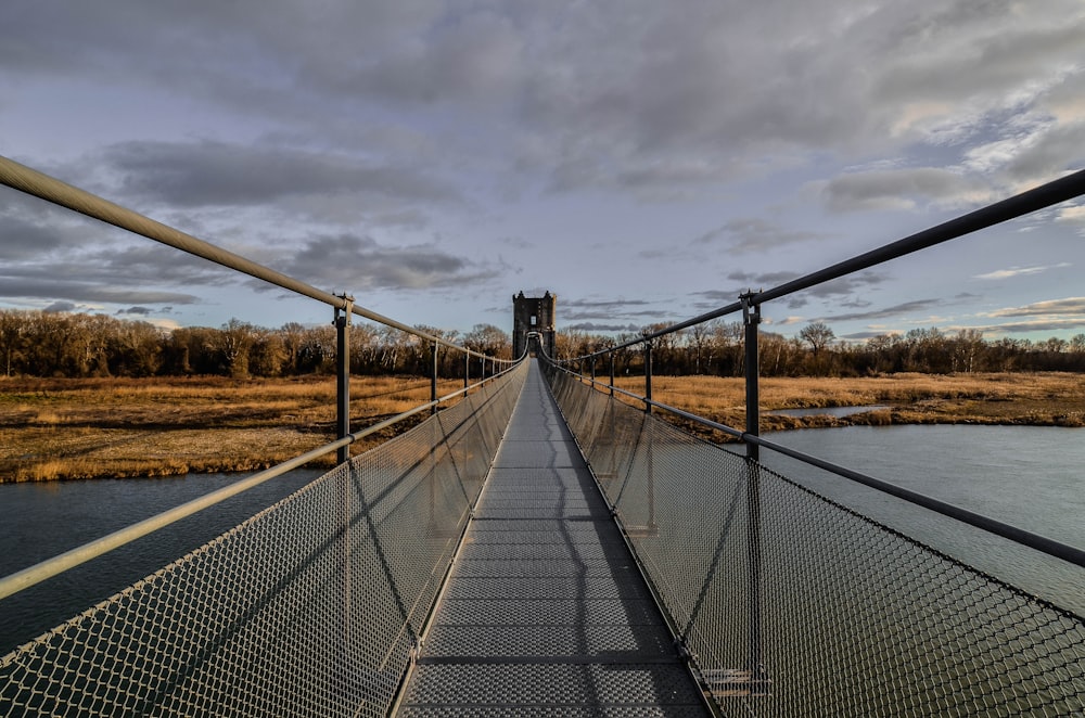 Graue Holzbrücke über den Fluss unter grau bewölktem Himmel