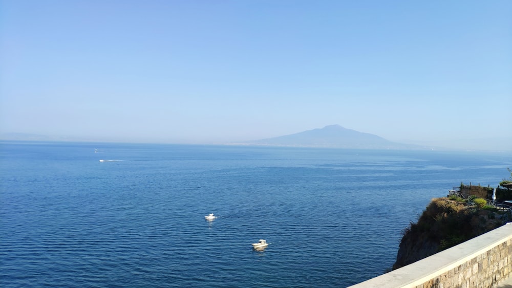 body of water near mountain during daytime