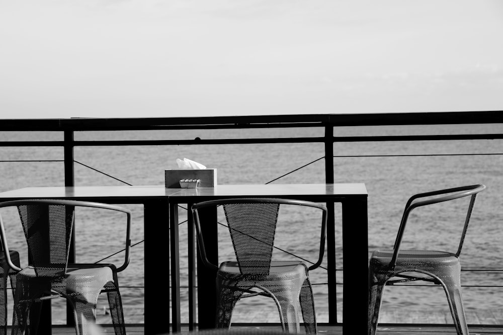 grayscale photo of a table and chairs