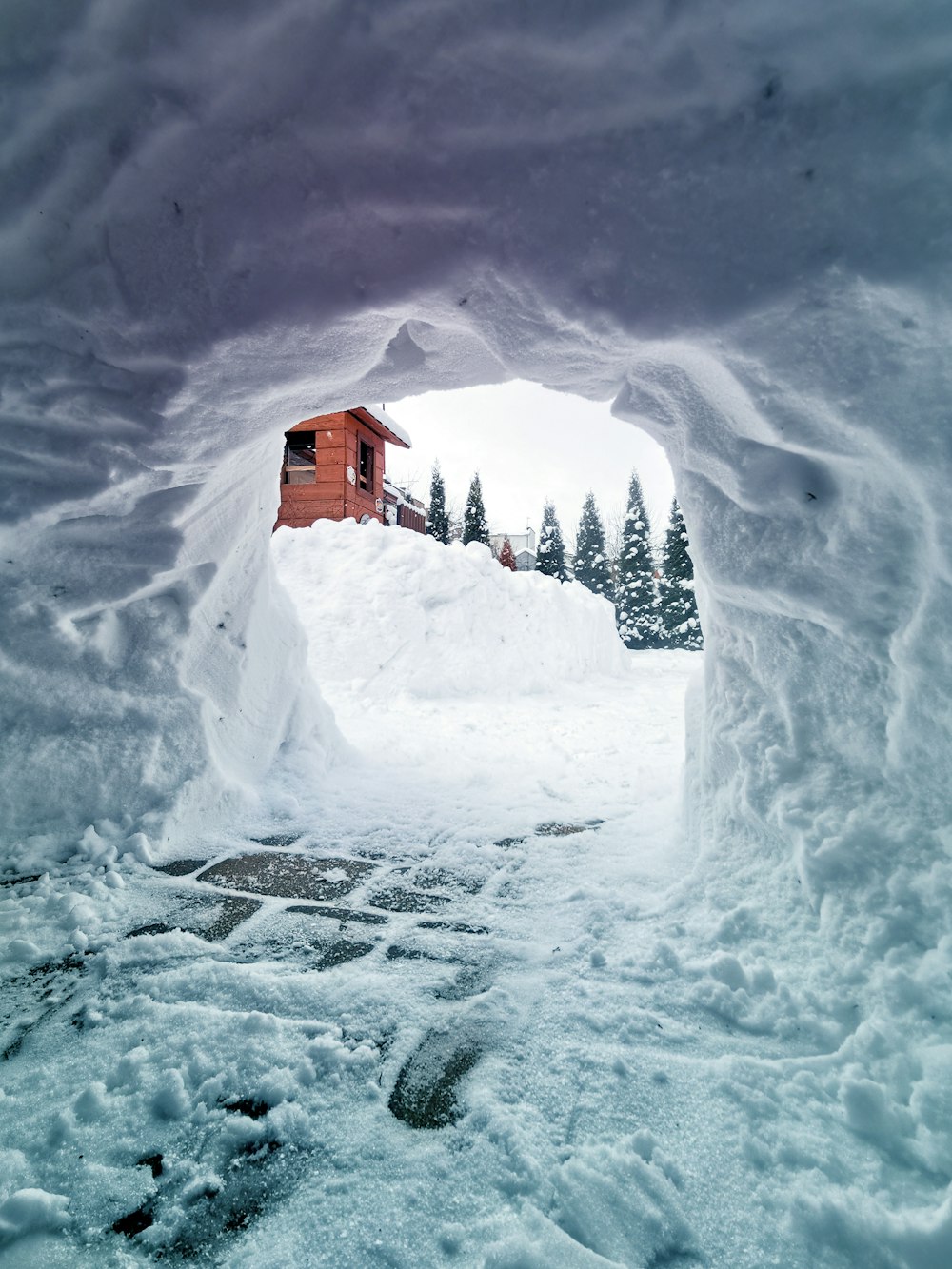 Braunes Holzhaus im schneebedeckten Boden