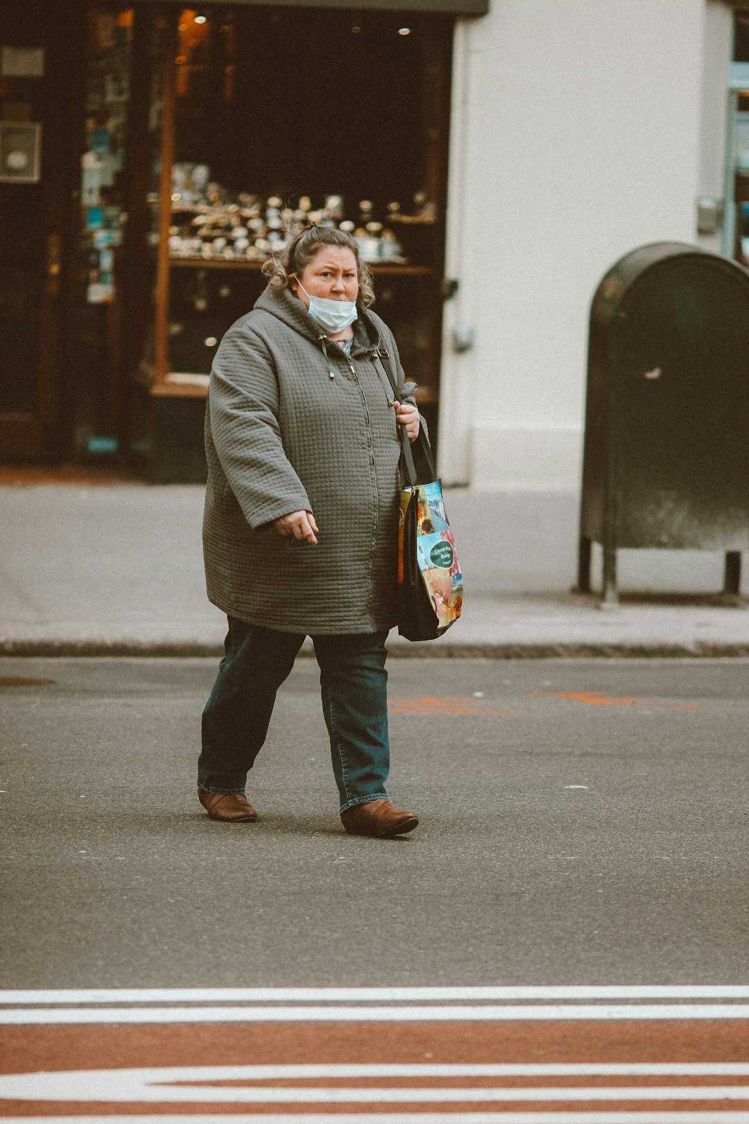 man in black coat holding blue and black leather handbag