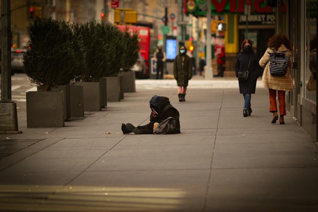 man in black jacket lying on sidewalk during night time