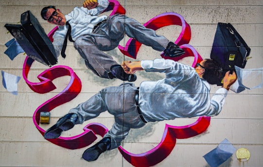 A mural depicts two men in business attire, with one appearing to have black hair and both wearing glasses. They are entangled and floating amidst swirling red ribbons and scattered papers, each holding a briefcase.
