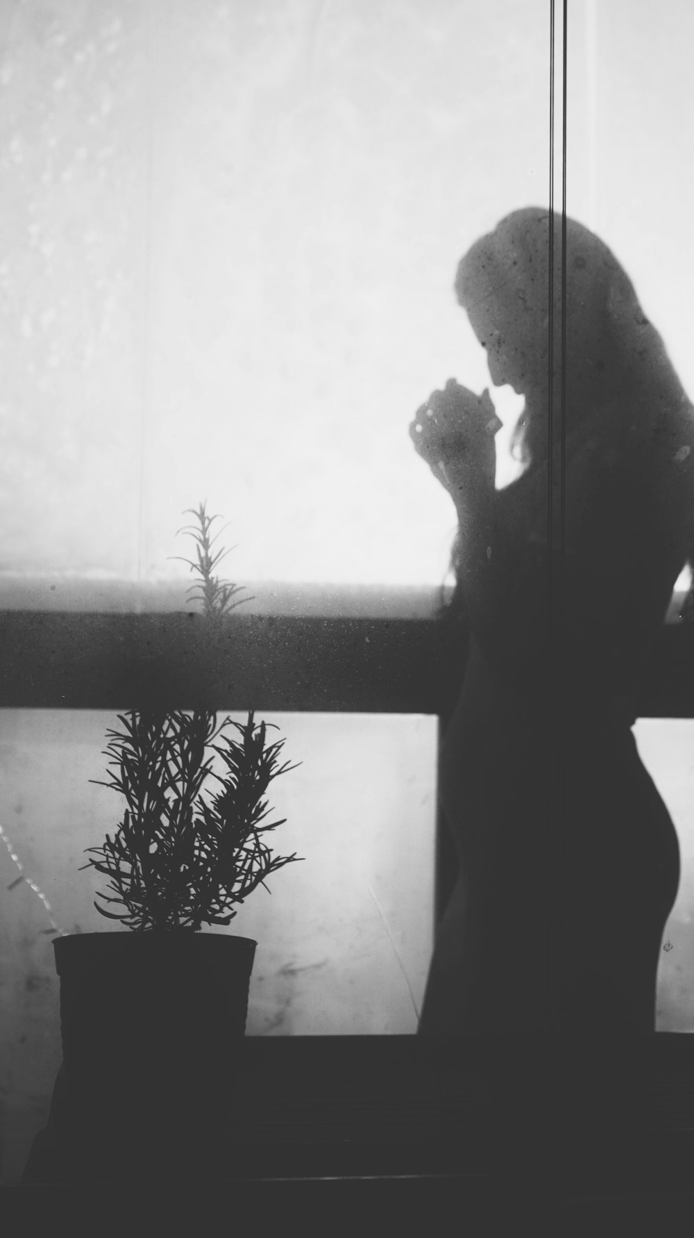 silhouette of person standing near window